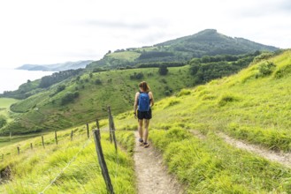 Tourist with backpack enjoying a hike in the basque country near sakoneta beach and its flysch in
