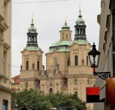 Church towers rising above the cityscape of prague, showcasing the city's rich architectural