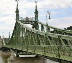 Liberty bridge, a green steel bridge, is standing over danube river in budapest, hungary,