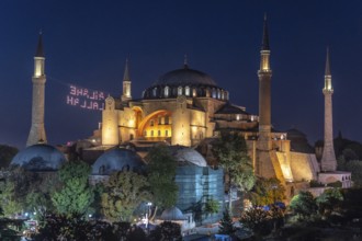 Hagia sophia illuminated at night with a drone light show displaying a religious message in the sky