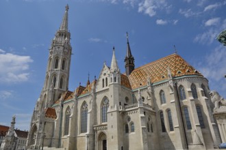 Matthias church with its colorful roof tiles and tall bell tower standing tall against a blue sky