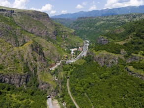 View of valley with roads, tunnels and houses in green mountain landscape, aerial view, landscape