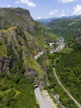 Landscape with road and tunnel between forested mountains and river, aerial view, landscape near