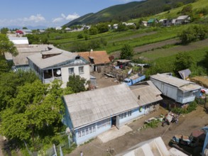 Rural scene with traditional buildings and view of fields and surrounding nature, aerial view,