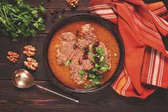 Fesenjan, an Iranian dish, stewed chicken, in walnut-pomegranate sauce, in an earthen pan,