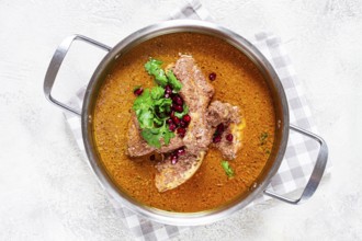 Fesenjan, an Iranian dish, stewed chicken, in a nut-pomegranate sauce, in a saucepan, light