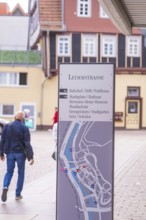 Signpost in a picturesque old town with half-timbered houses in the background, small town pearl