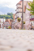 A pink bicycle decorates the street in front of a row of historic houses, small town of Perle Calw,