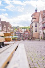 Inviting street scene with cobblestones and half-timbered houses under a blue sky, small town of