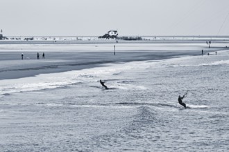 Two kitesurfers in the evening, monochrome, Sankt Peter-Ording, Eiderstedt peninsula, Wadden Sea
