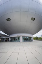 Dome-shaped modern building with prominent entrance area and architectural details, BMW Welt,