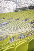 Detailed view of green rows of seats in a modern stadium with glass roof structure, Olympic Park,