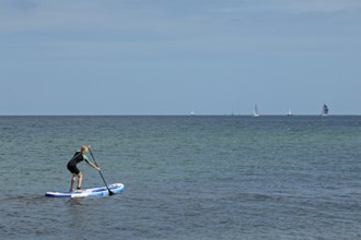 Girl stand-up paddling, Strande, Schleswig-Holstein, Germany
