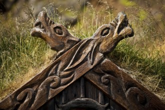 Detail of the wood-carved gable decoration on the Viking house covered with turf at Gudrúnarlaug,