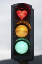 Traffic lights with green light, yellow light and red light in the shape of a heart, symbolic image