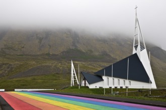 Street painted in the colours of the rainbow and the fish-shaped church designed by Hákon