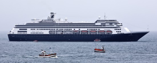 Cruise ship at sea with several small excursion boats for whale watching, Husavik, Iceland