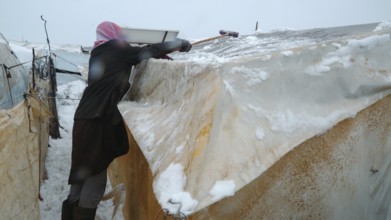 Displaced Syrian families and children living in refugee camps during harsh winter conditions,