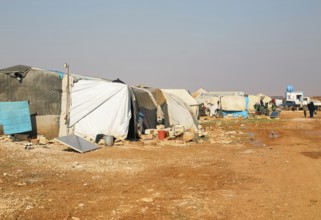 Worn-out tents housing Syrian refugees near the Turkish border, showing the dire humanitarian