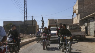 Fighters from the Free Syrian Army celebrate victory after capturing villages that were under the