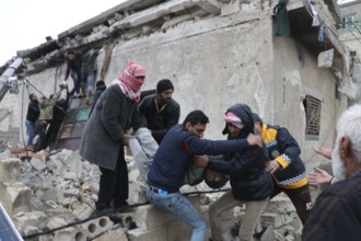 Civil defense teams attempt to rescue civilians trapped under the rubble after a powerful