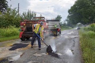 Glendora, Michigan - A worker for the Berrien County Road Department patches potholes on Wagner