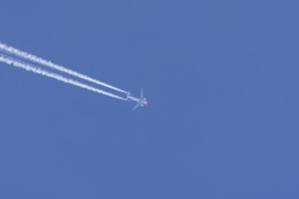Boeing 737 jet passenger aircraft of Norweign Air with a vapour trial or contrail behind flying in