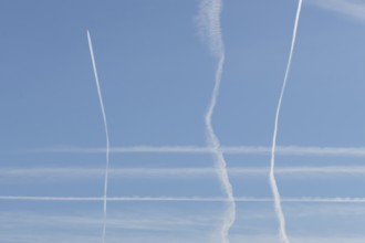 Jet aircraft vapour trails or contrails in a blue sky, England, United Kingdom