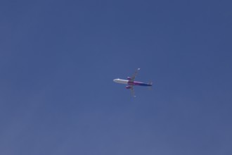 Airbus A321 jet aircraft of Wizz Air airlines in flight in a blue sky, England, United Kingdom