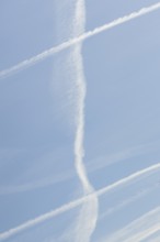 Jet aircraft vapour trails or contrails in a blue sky, England, United Kingdom