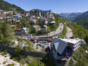 Winding road through a mountain town with a church and traditional architecture, clear view of the