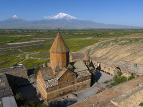 Close-up of an old monastery against a mountain backdrop under a clear sky, aerial view, Chor Wirap