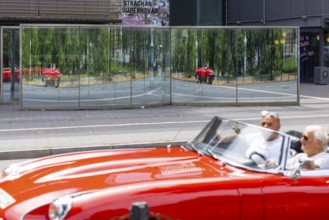 Mirror in front of the Kunsthalle Mannheim. Distorted vehicles are reflected in the glass.