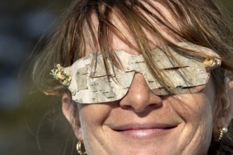 Woman wearing glasses made from birch bark, Gaspesie national park, Province of Quebec, Canada,