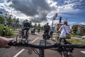 Cycling in the Dutch city of Utrecht, cycle path separated from the carriageway for cars, heavy