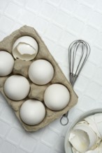 White eggs in packaging with beaters