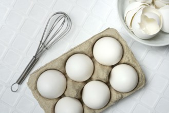 White eggs in packaging with beaters