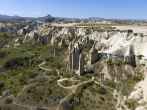 A hilly landscape with iconic rocks and roads in Cappadocia, aerial view, Love Valley, Göreme
