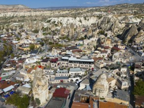 Cityscape in Cappadocia with numerous buildings and characteristic rock formations, aerial view,