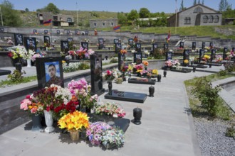 Several decorated graves in a well-tended landscape, extensive floral decorations, graves of 2020,