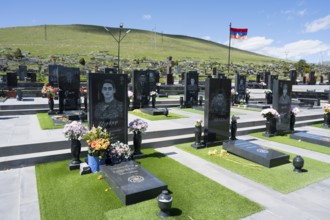 Cemetery with memorial plaques and flowers, peaceful atmosphere under a blue sky, graves of 2020,