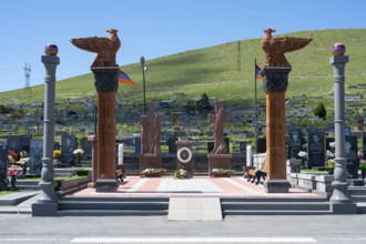 Impressive monument with eagle statues in a peaceful cemetery setting, memorial to the heroes of