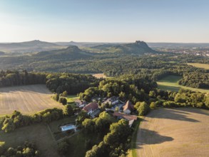 Luftbild von einer Hofsiedlung mit dem Berggasthaus Rosenegg, dahinter die Hegauberge,