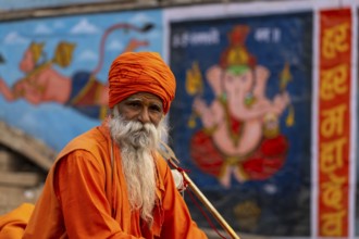 Indian Sadhu, with picture of Ganesha in the background, Bangali Tola, Varanasi, Uttar Pradesh,