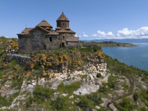 Historic church on a hill overlooking a lake under a bright blue sky, aerial view, Hajrawank