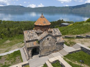 Tranquil view of a historic monastery with mountain and lake views under a clear sky, aerial view,