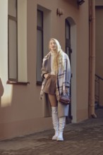 The young woman exudes confidence in a chic autumn outfit featuring a brown skirt and white