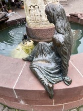 Sculptures figures of princess and frog holding golden ball representation from fairy tale the frog