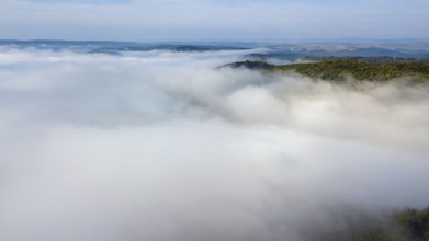 Bird's eye view of aerial view of high fog lying over valleys of low mountain ranges, Germany