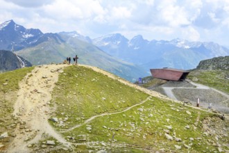 View of left hills Hiking trails lead to the summit with Christian cross, centre right Timmelsjoch